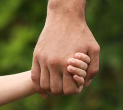 Father holding son's hand