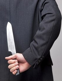 Businessman with a knife behind his back