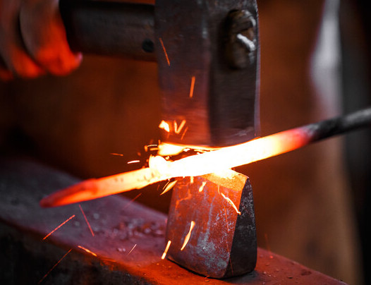 Blacksmith hammering iron